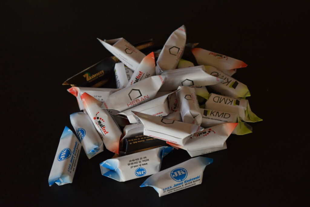 Krówki cukierki z, które owinięte są w papierek z nadrukiem reklamowym lub logiem